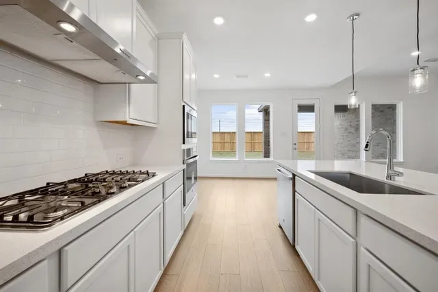 a view of kitchen with stainless steel appliances granite countertop a stove and a refrigerator