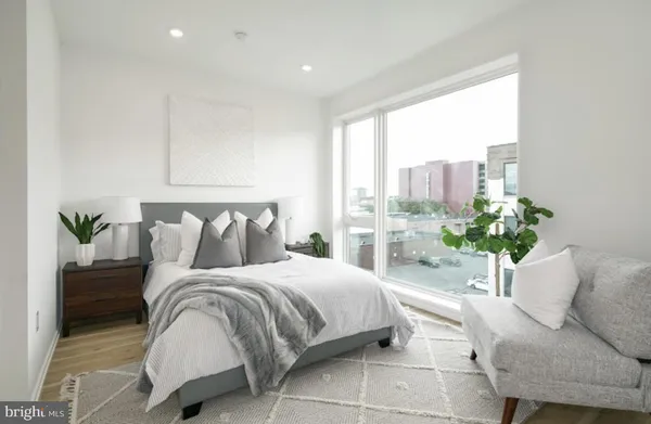 a bedroom with a large bed and a potted plant