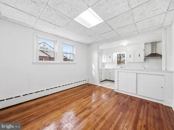 a view of a kitchen with wooden floor and electronic appliances