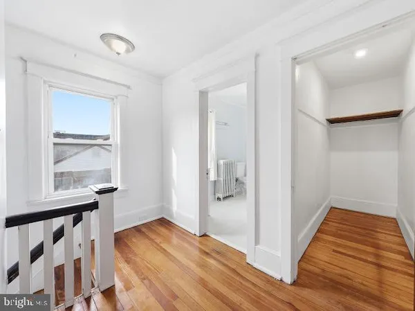 a view of a room with wooden floor and a bathroom