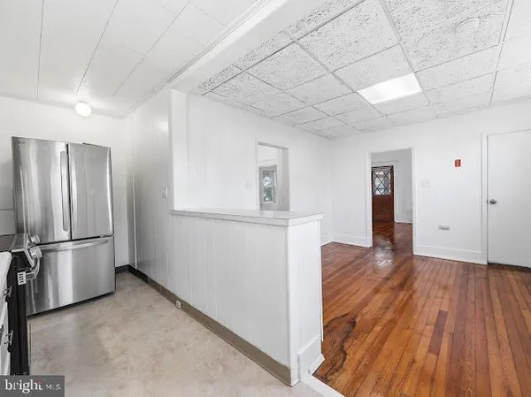 a view of empty room with wooden floor and window