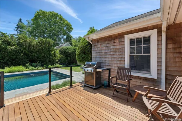 a view of a deck with table and chairs with wooden floor and fence