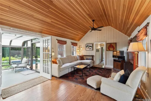 a living room with furniture a wooden floor and next to a large window