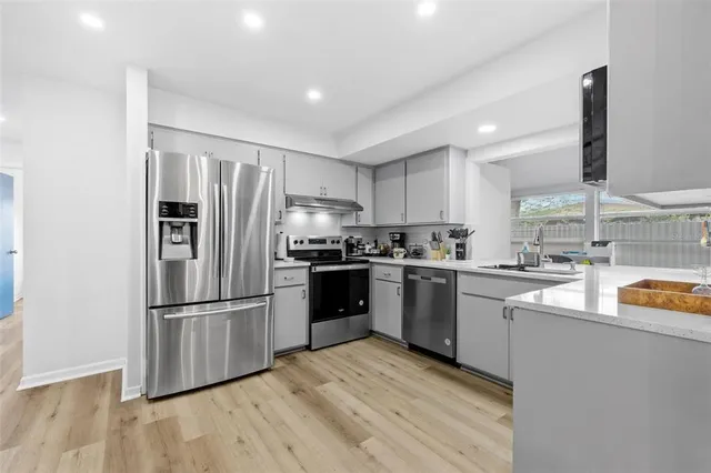 a kitchen with granite countertop stainless steel appliances and wooden cabinets