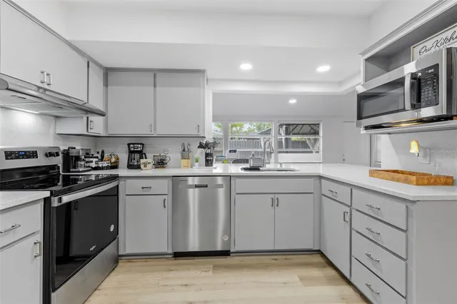 a kitchen with granite countertop cabinets stainless steel appliances and a counter space