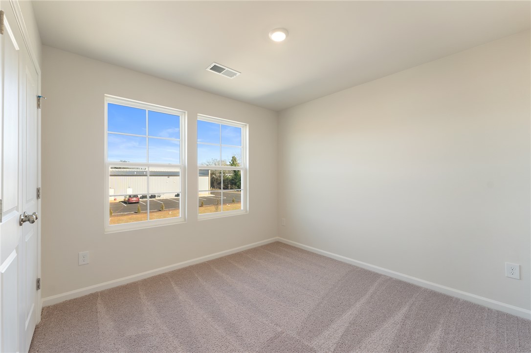 138 Cotesworth Street Pendleton, SC 29670 - Photo 13 of 19 This airy bedroom offers soft carpeting and ample natural light, creating a serene personal retreat.