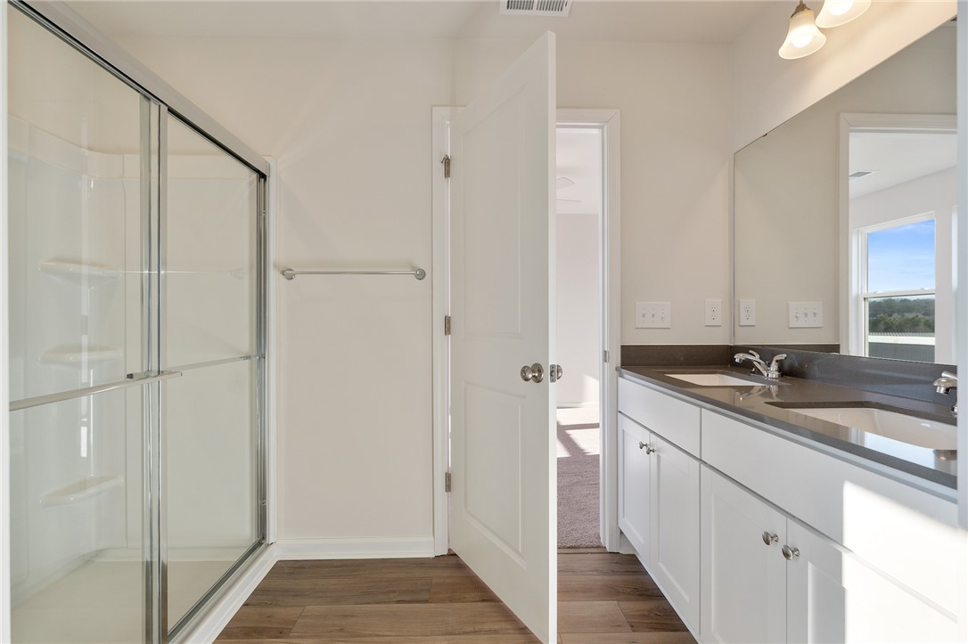 138 Cotesworth Street Pendleton, SC 29670 - Photo 9 of 19 A well-appointed bathroom features dual vanities and a spacious shower, blending practicality with modern design.