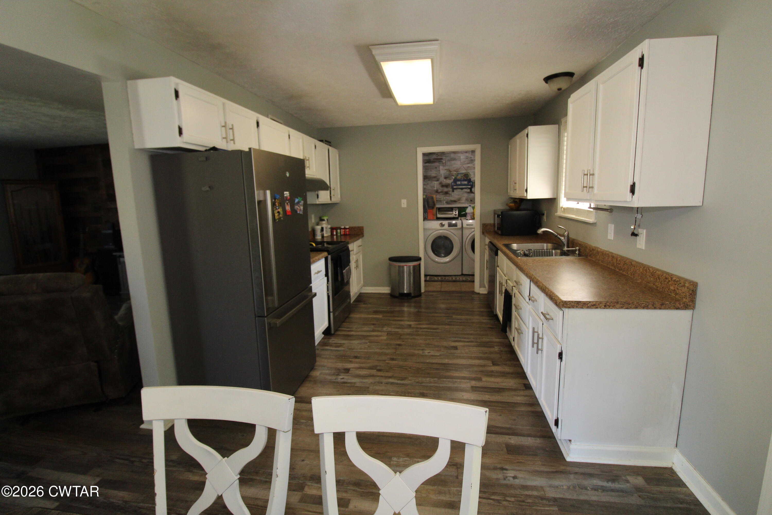 33 Kipling Drive Jackson, TN 38305 - Photo 8 of 20 a kitchen with granite countertop a refrigerator a sink a stove and white cabinets