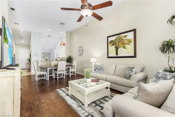 a living room with furniture kitchen view and a chandelier