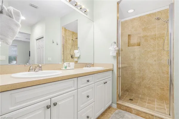 a bathroom with a granite countertop sink a mirror a shower and a