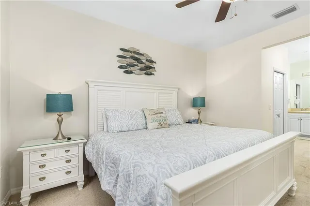 a bedroom with a bed and a lamp on dresser