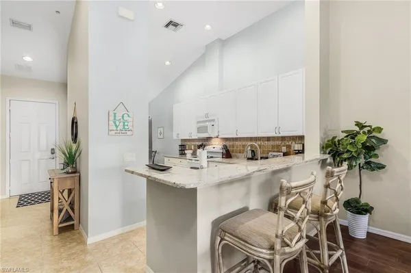a kitchen with stainless steel appliances a sink a table and chairs in it
