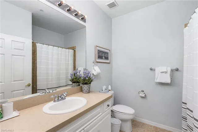 a bathroom with a sink toilet and a mirror