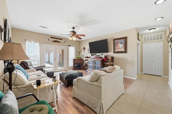 a living room with furniture a flat screen tv and kitchen view