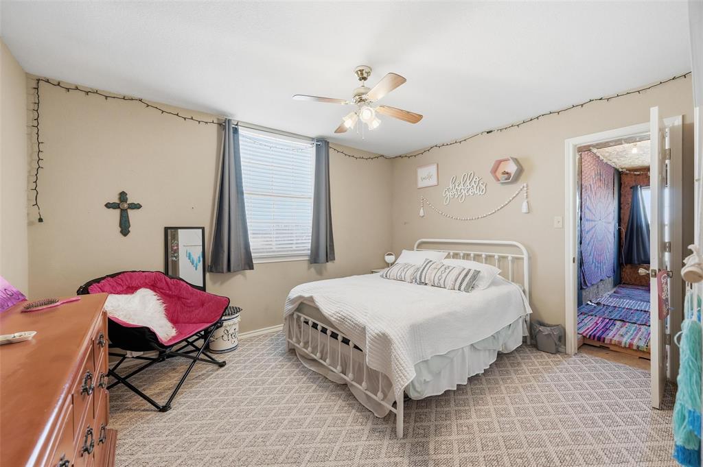 346 Forreston Road Waxahachie, TX 75165 - Photo 18 of 36 a bedroom with a bed and a chandelier