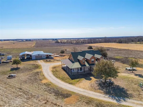 an aerial view of a house with a yard and lake view