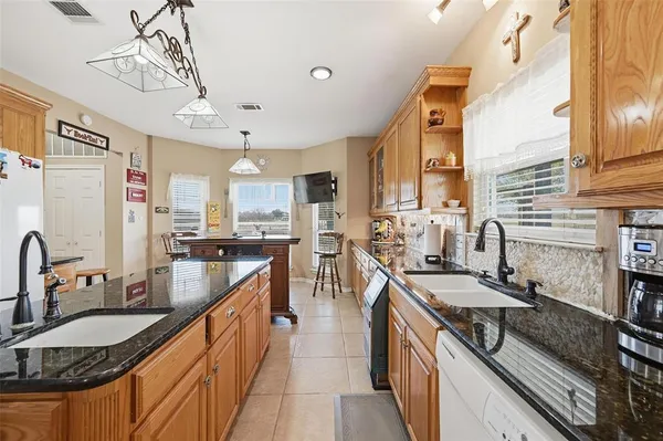 a large kitchen with kitchen island a sink stainless steel appliances cabinets and a counter top space