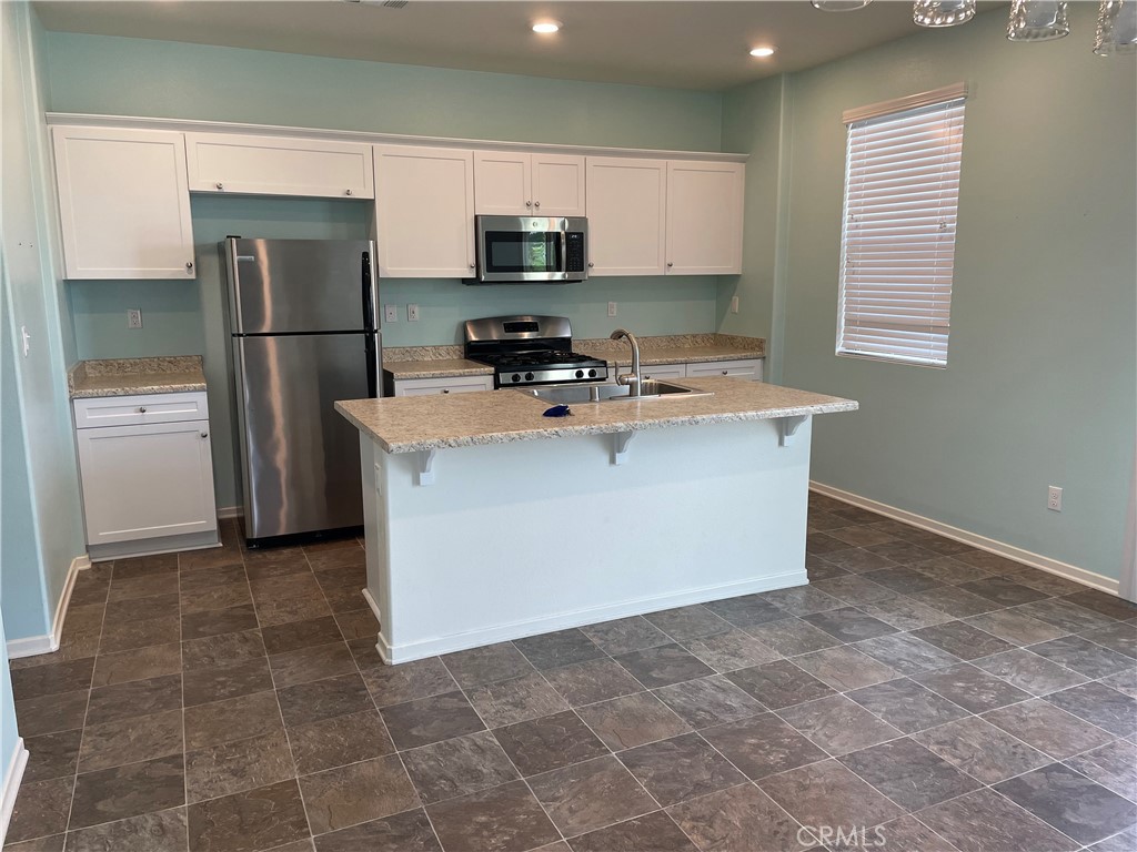 30433 Village Knoll Drive Menifee, CA 92584 - Photo 2 of 12 a kitchen with stainless steel appliances a refrigerator stove top oven and a sink