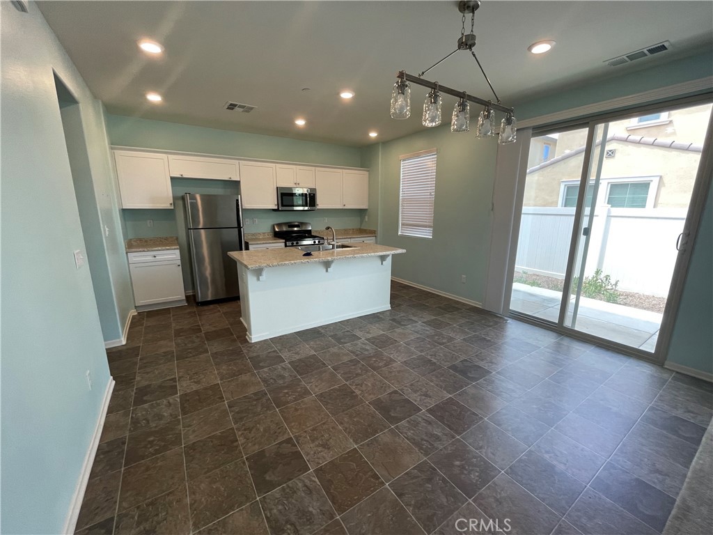 30433 Village Knoll Drive Menifee, CA 92584 - Photo 3 of 12 a view of a kitchen with microwave and refrigerator