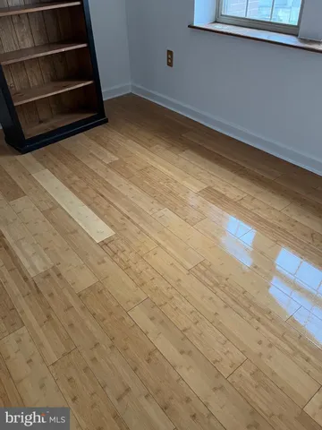 a view of a room with wooden floor and window