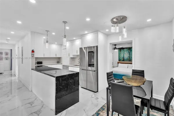 a kitchen with kitchen island stainless steel appliances a sink and a refrigerator