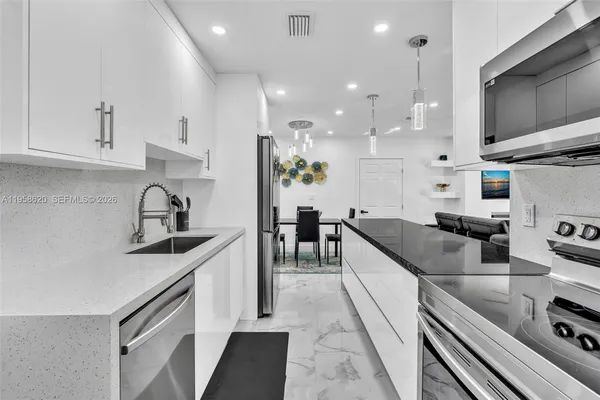 a kitchen with stainless steel appliances granite countertop a sink stove and cabinets