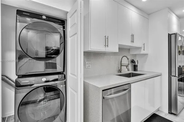 a utility room with sink dryer and washer