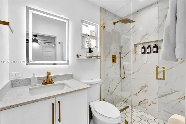 a bathroom with a sink a toilet and shower