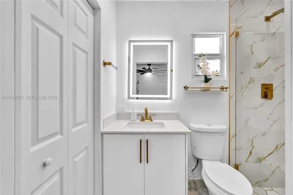 a bathroom with a sink vanity mirror and toilet