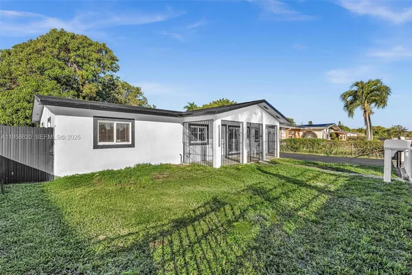 a view of a house with backyard and a tree