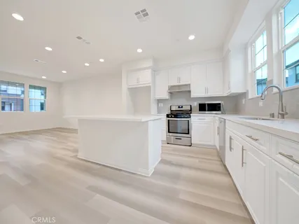 a large white kitchen with cabinets and stainless steel appliances