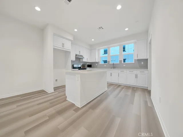a kitchen with white cabinets and white appliances