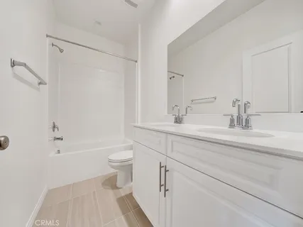 a bathroom with a double vanity sink toilet and shower