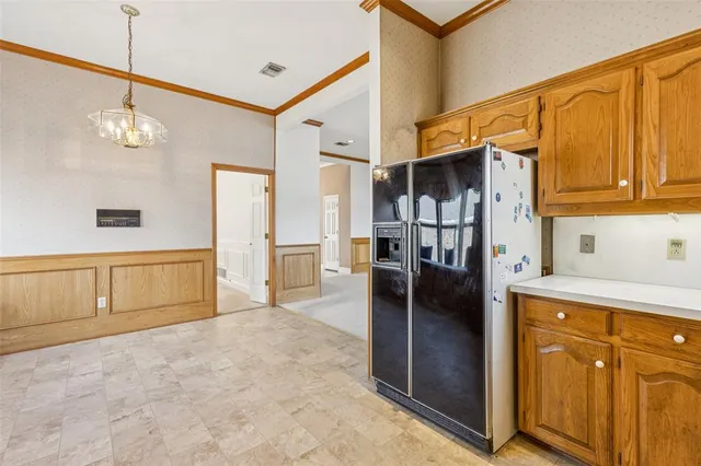 a kitchen with stainless steel appliances granite countertop a refrigerator a oven and a sink with cabinets
