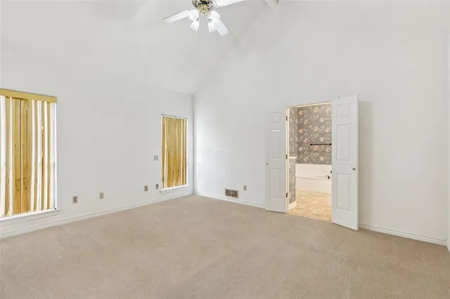 an empty room with chandelier fan