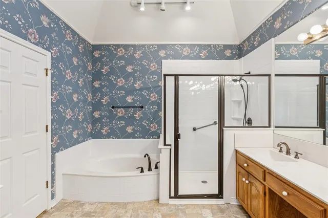 a bathroom with a bathtub a mirror a vanity and a shower