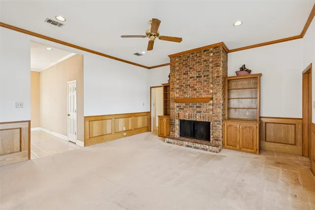 a view of an empty room with a fireplace and a window