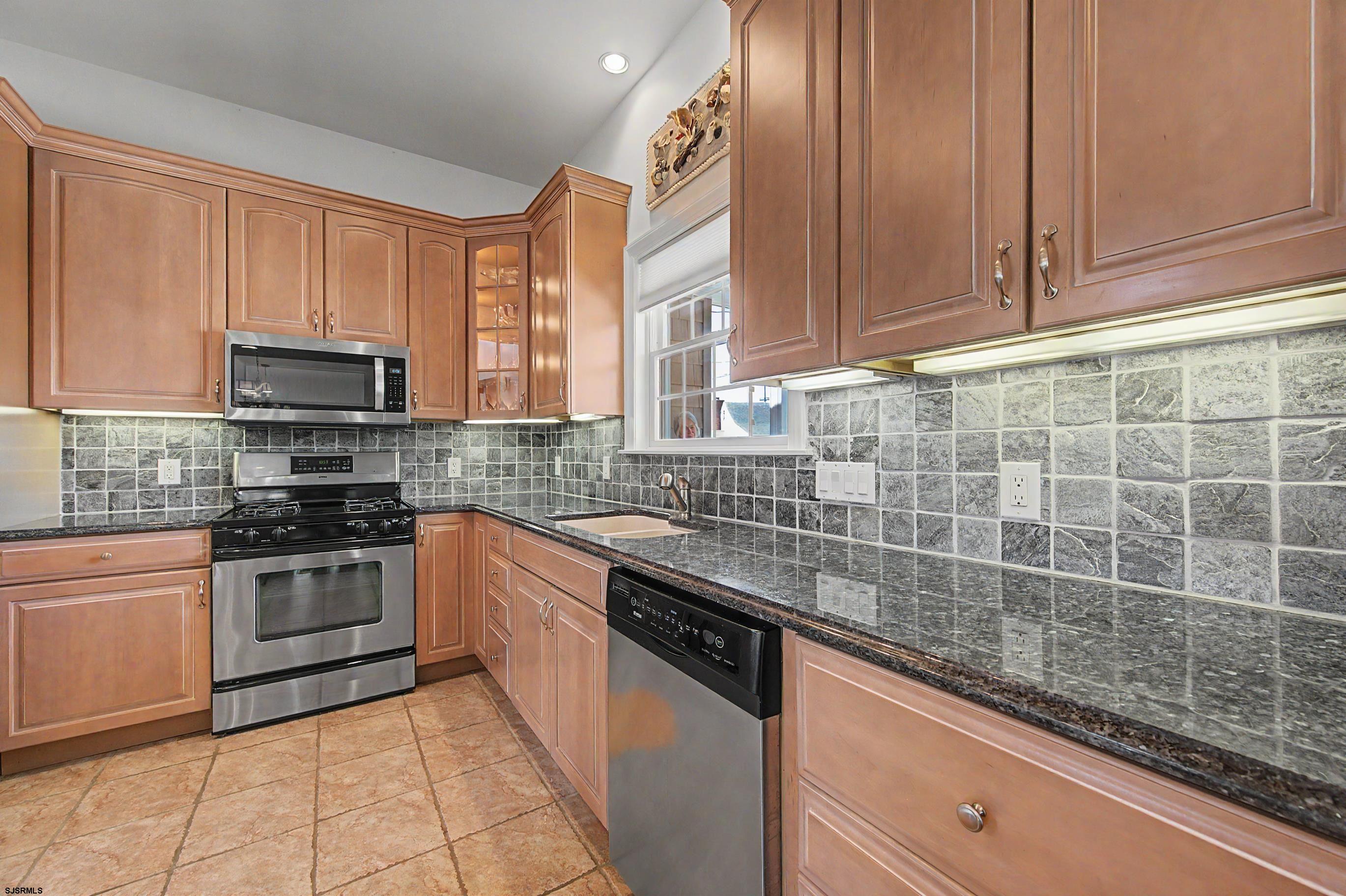 212 17th Street South Brigantine, NJ 08203 - Photo 9 of 37 a kitchen with stainless steel appliances granite countertop a sink stove and microwave