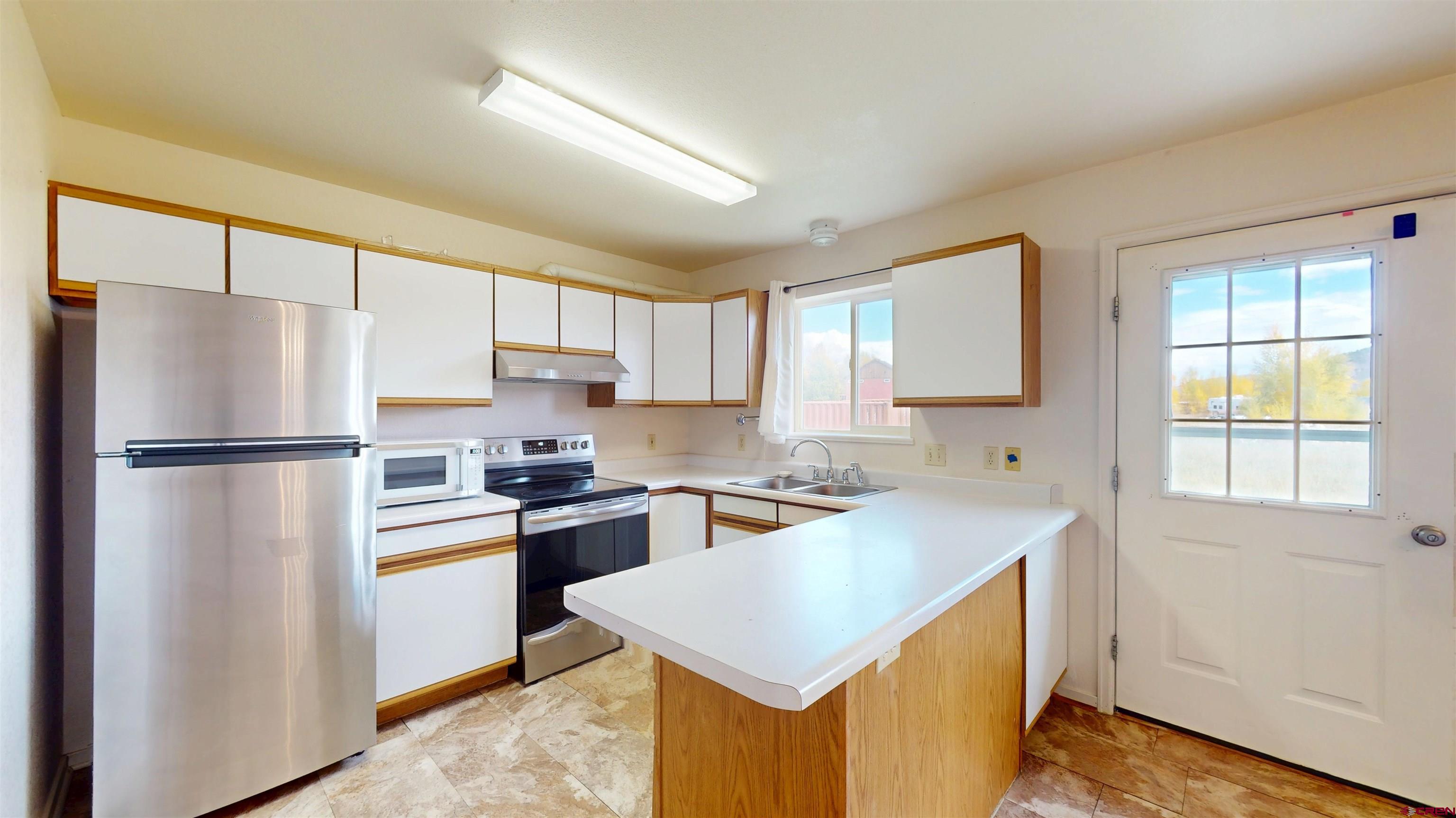 314 South 5th Street Gunnison, CO 81230 - Photo 11 of 26 a kitchen with a refrigerator a stove a sink dishwasher and a refrigerator