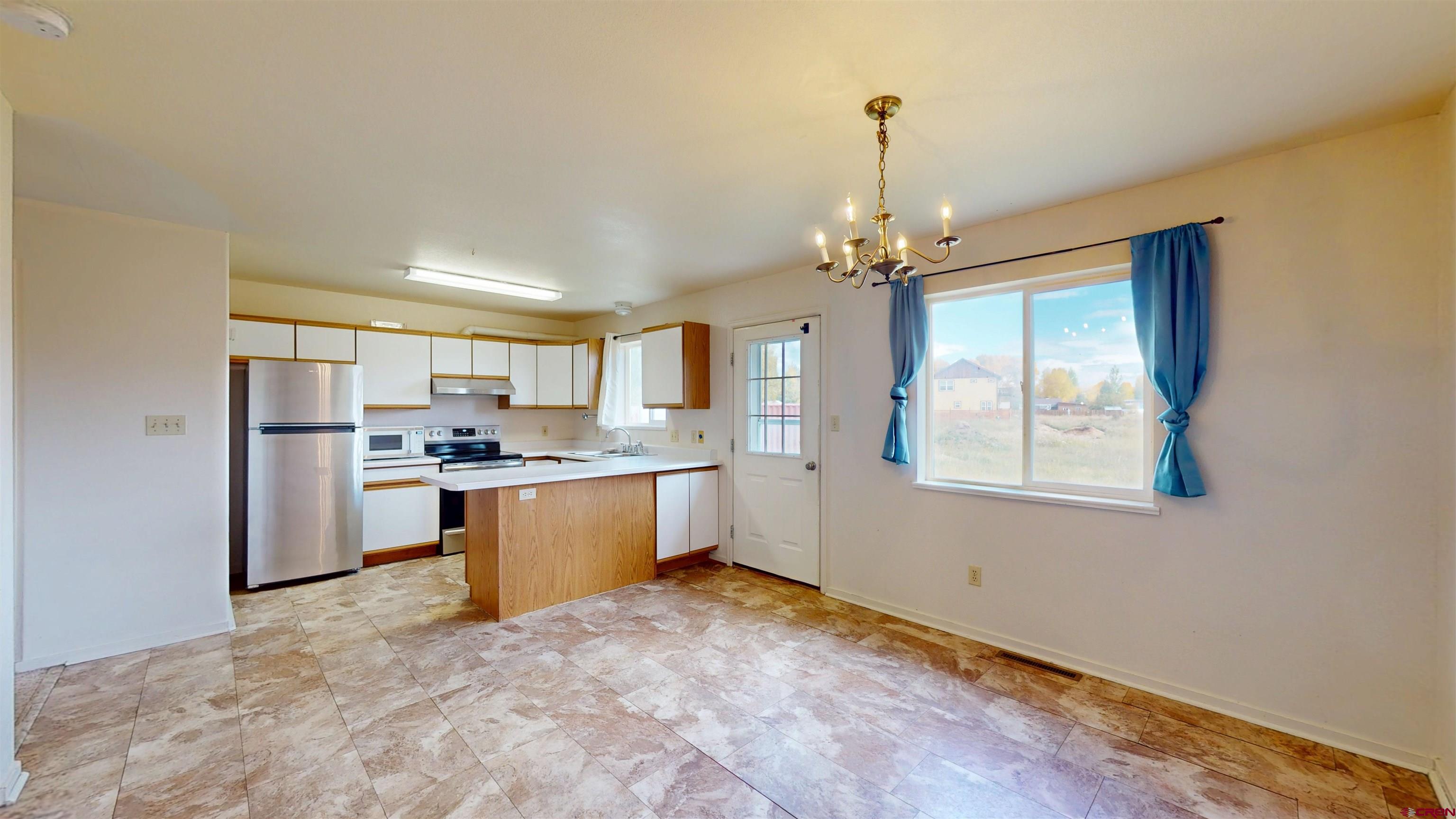 314 South 5th Street Gunnison, CO 81230 - Photo 15 of 26 a large kitchen with cabinets and stainless steel appliances