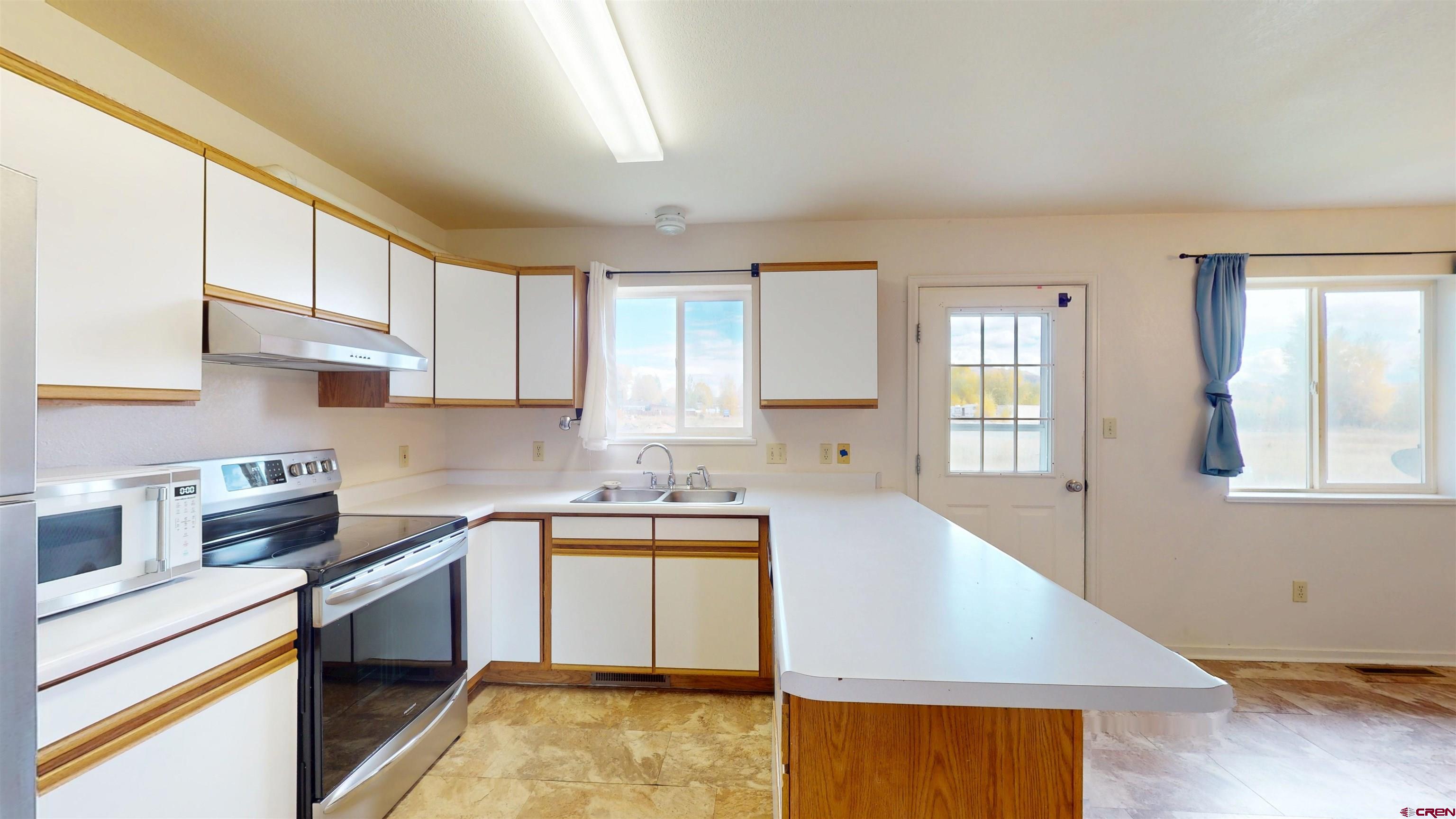 314 South 5th Street Gunnison, CO 81230 - Photo 10 of 26 a kitchen with stainless steel appliances granite countertop a sink stove and cabinets