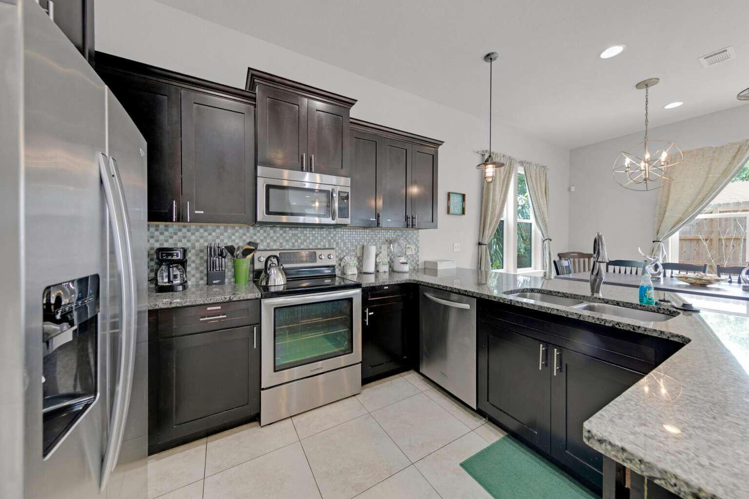 228 Miami Street Miramar Beach, FL 32550 - Photo 7 of 20 a kitchen with stainless steel appliances granite countertop a sink a stove a refrigerator and a microwave