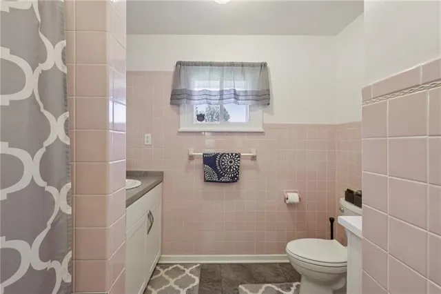 a bathroom with a toilet and a shower curtain