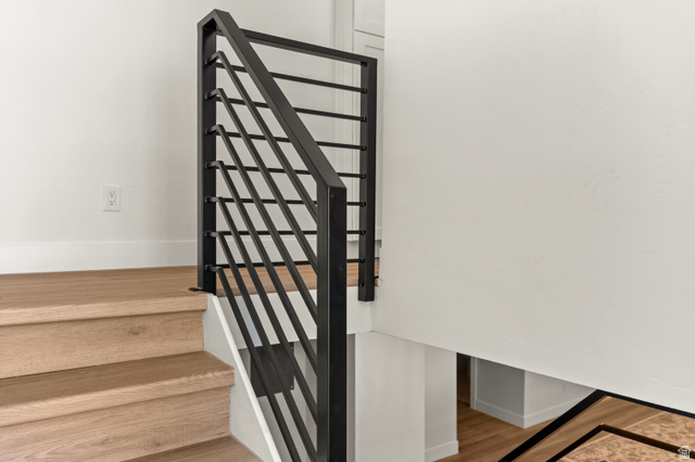 189 West Center Street Midvale, UT 84047 - Photo 27 of 64 Staircase featuring light wood-finish treads and risers, white baseboards, and a contemporary black metal balustrade with horizontal railings