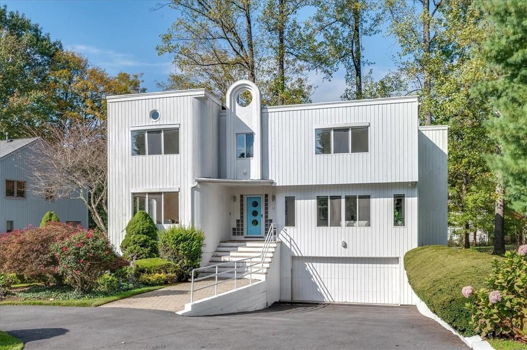 a view of a white house with large windows and a tree