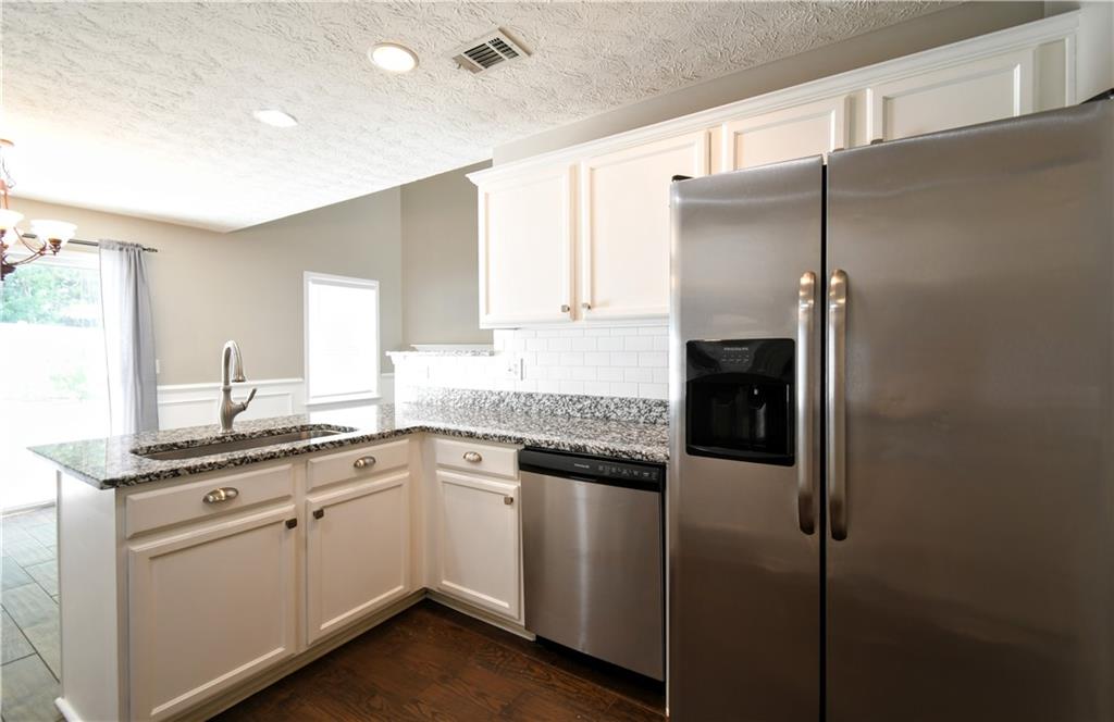 6215 Smoke Ridge Lane Cumming, GA 30041 - Photo 13 of 32 a kitchen with a sink and refrigerator