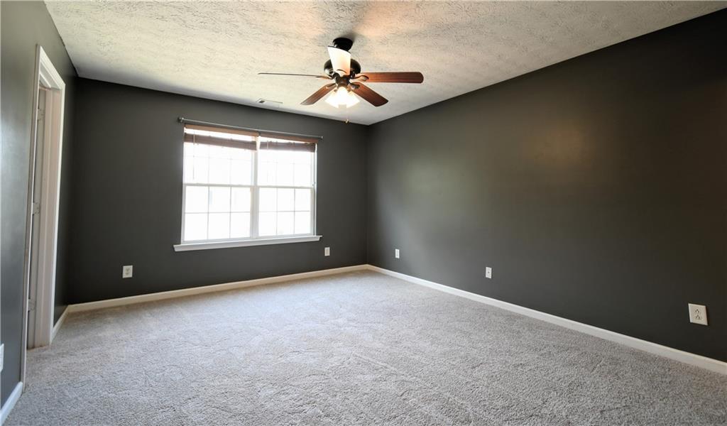 6215 Smoke Ridge Lane Cumming, GA 30041 - Photo 19 of 32 an empty room with windows and ceiling fan