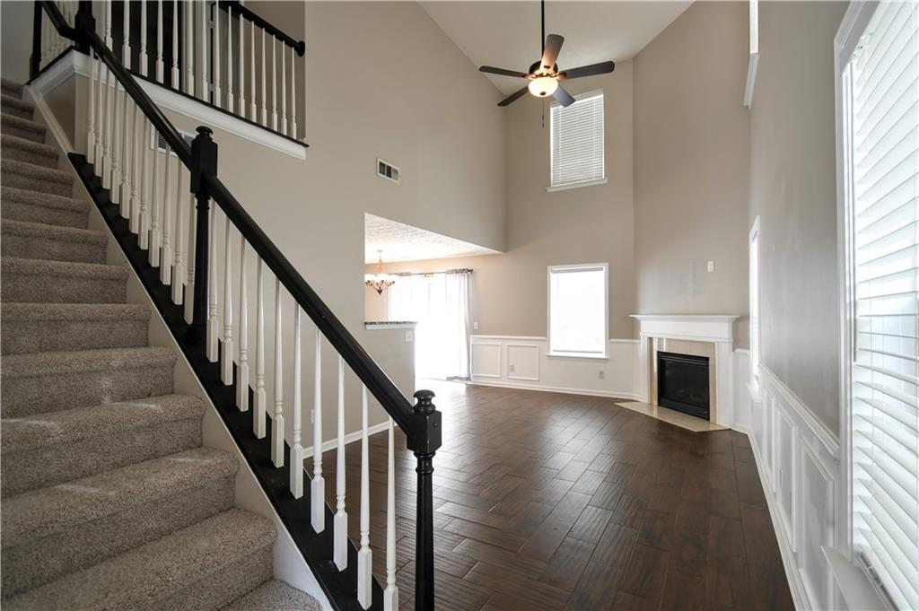 6215 Smoke Ridge Lane Cumming, GA 30041 - Photo 3 of 32 a view of a livingroom with wooden floor fireplace and windows