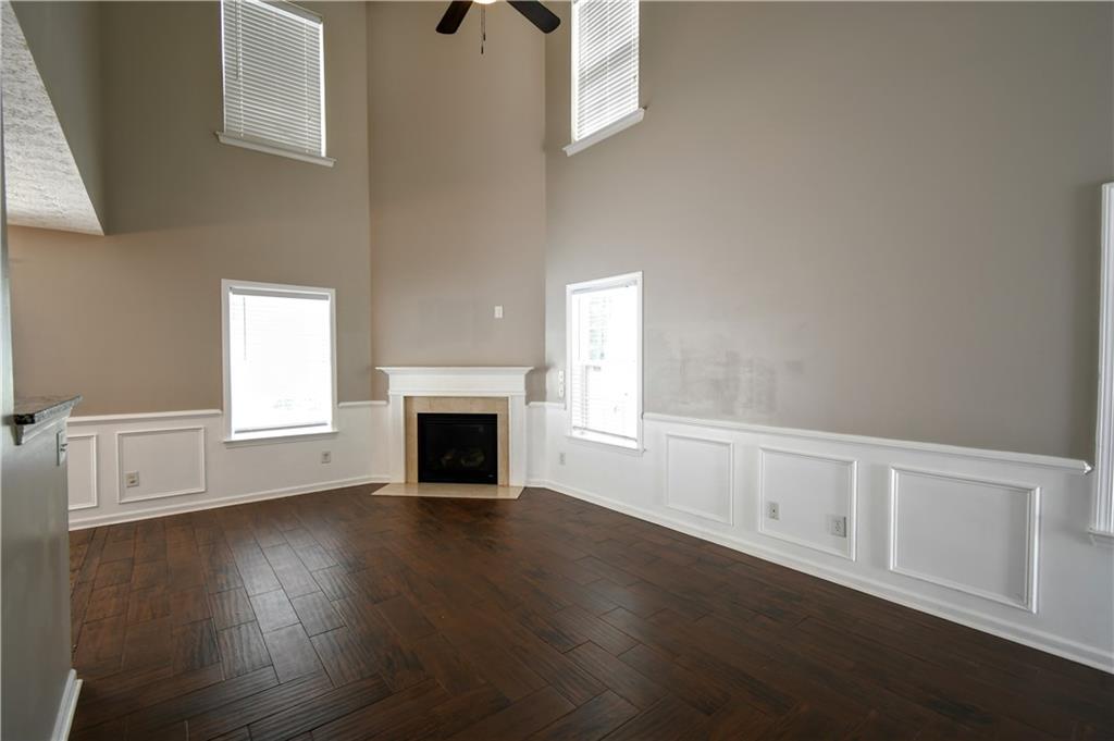 6215 Smoke Ridge Lane Cumming, GA 30041 - Photo 5 of 32 an empty room with wooden floor fireplace and windows