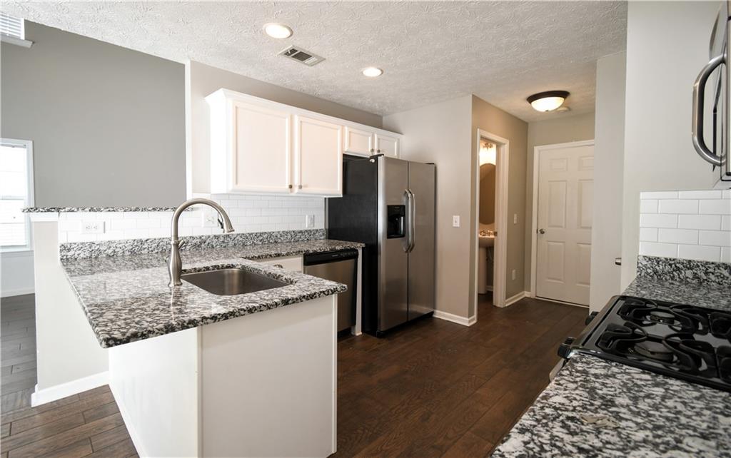 6215 Smoke Ridge Lane Cumming, GA 30041 - Photo 9 of 32 a kitchen with granite countertop a refrigerator and a sink